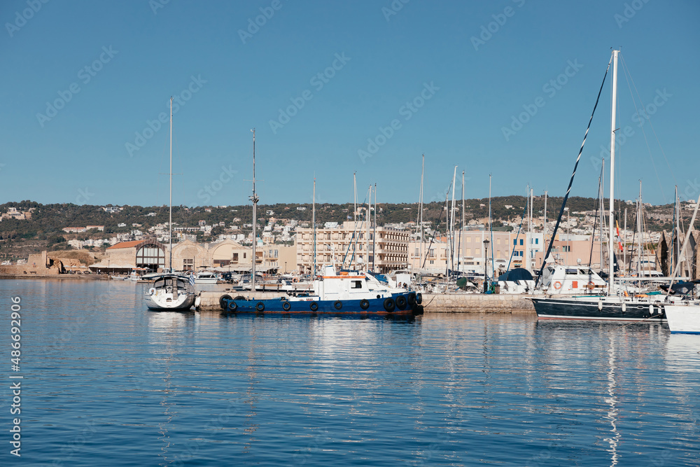 Yachts boats in picturesque old port of Chania on sunny day and reflection on water, island Crete, Greece. Beautiful landmark and tourist destination of Crete island with space for text. .