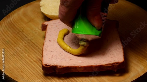 putting mustard on a Bavarian Leberkaese