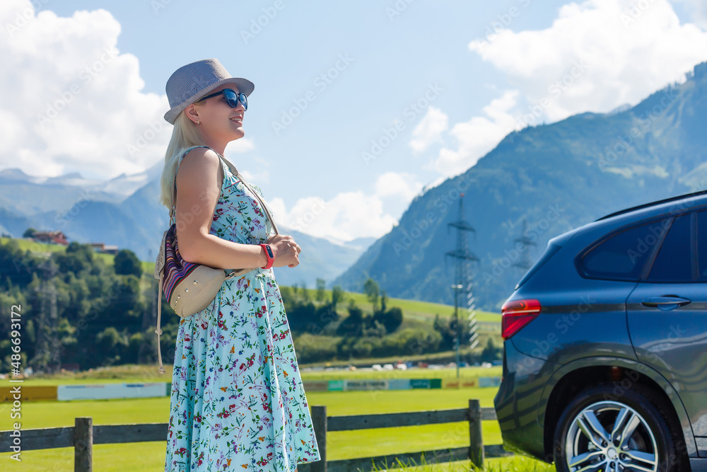 Young woman standing near her car on the mountain