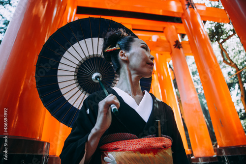 Beautiful japanese senior woman walking in the fushimi inari shrine in Kyoto photo