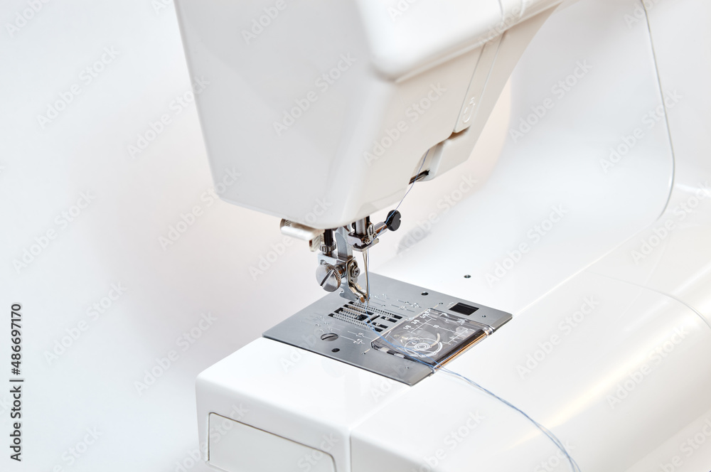 Sewing machine working part, replacement foot. Sewing machine with thread, closeup