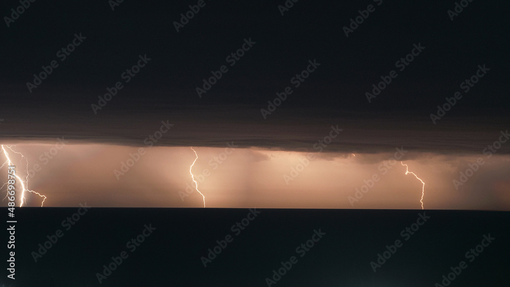 The concept of a scientific project in astrophysics. A row of lightning over the surface of the sea under the black sky The concept of a scientific project in astrophysics. A row of lightning over the surface of the sea under the black sky