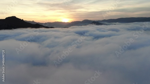 Flights over clouds and mountain peaks at sunset © vagon