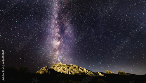 The concept of a scientific project on astronomy and astrophotography. The Milky Way in the starry sky over the Karadag mountain range on a summer night