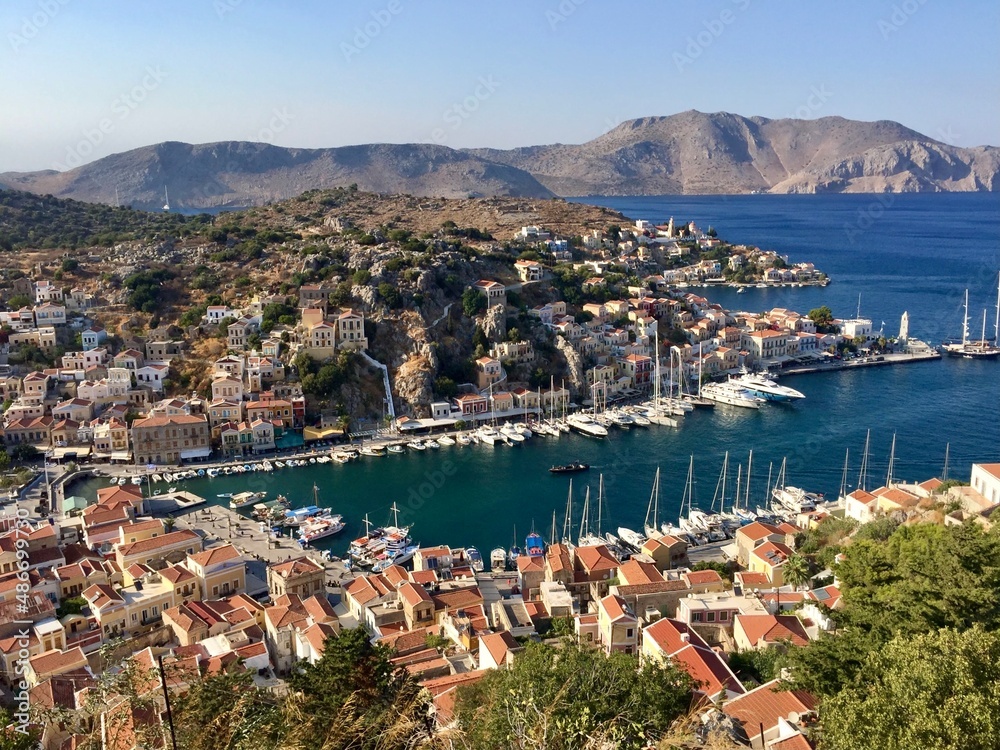 Symi island panoramic view from the top of hill. Greece. Aerial view. Marina, yachts, colourful houses, mountain. Dodecanese islands, Aegean sea. Greek island