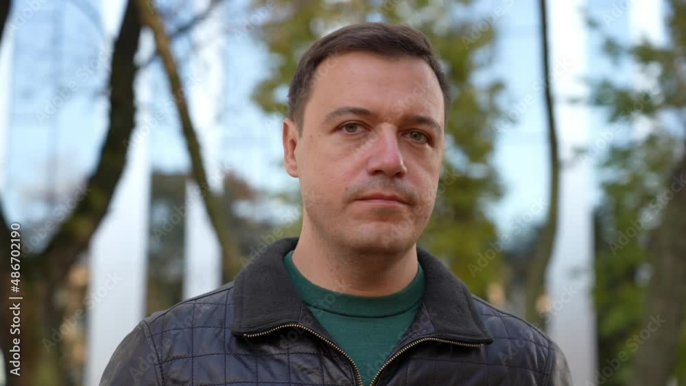 Millennial man shakes his head at camera with frown. Outdoor portrait of man shaking head to reject Millennial man shakes his head at camera with frown. Outdoor portrait of man shaking head to reject