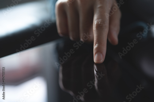 Close up of woman finger touching on digital tablet screen with reflection, business and technology concept
