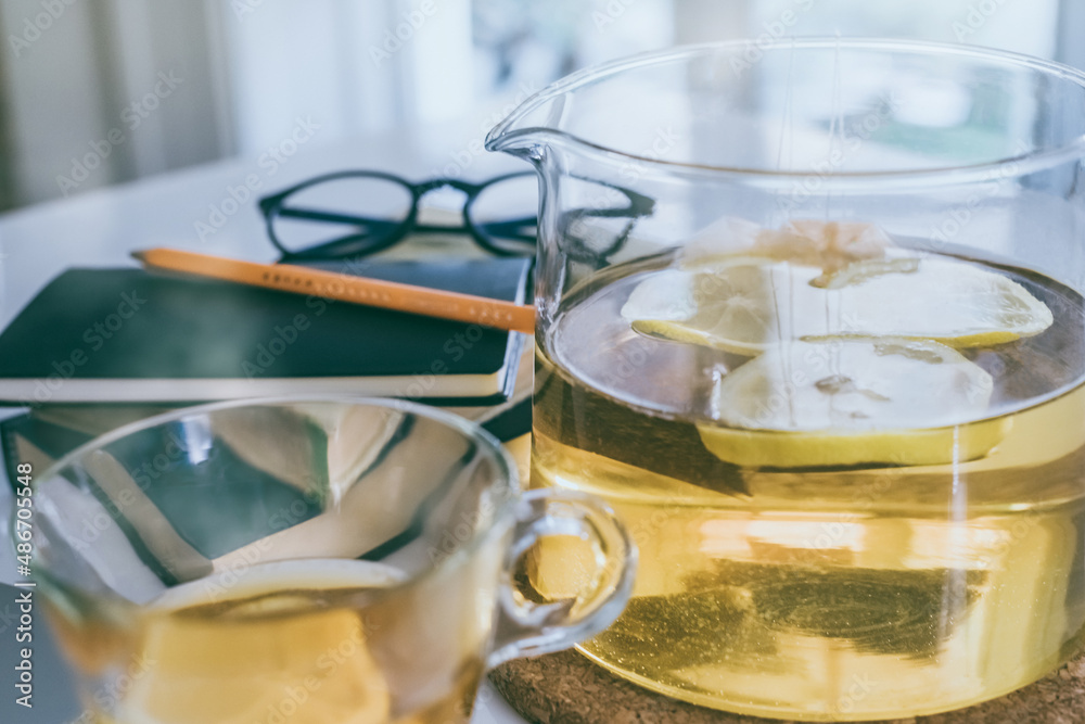 Morning time at home healthy breakfast organizer and cup of lemon tea on table. Natural meal at work in remote office, health hot drinks. Freelance desktop workspace. Home working, schooling concept.