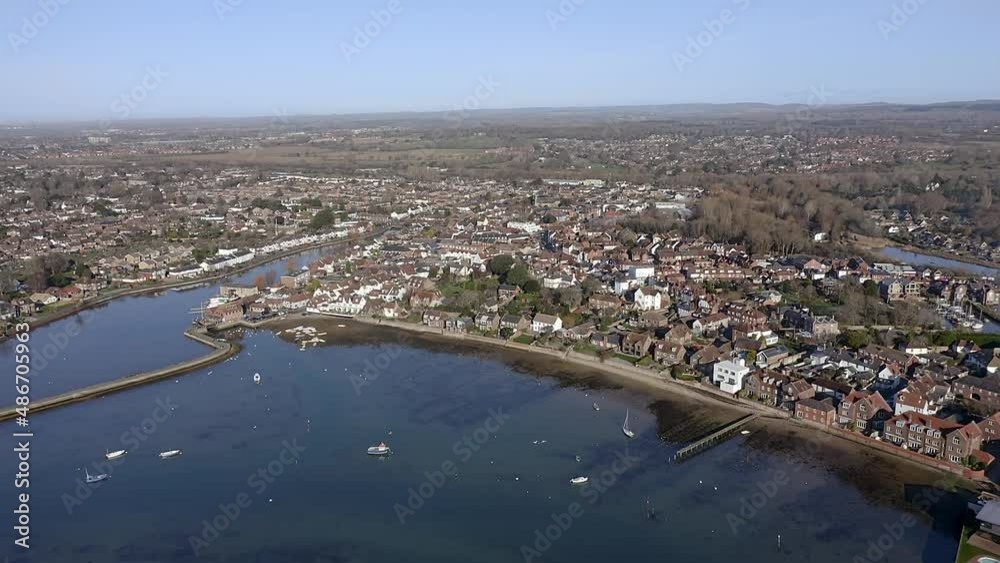 Aerial over Emsworth estuary as two swans fly over the water towards the promenade.