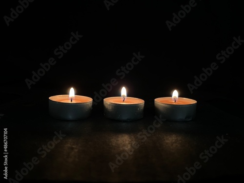 Burning scented candles isolated on black background.