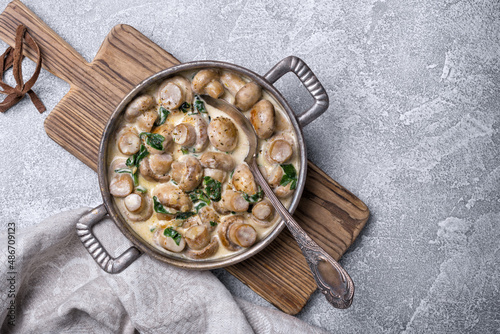 Frying pan of mushrooms in cream sauce with spinach