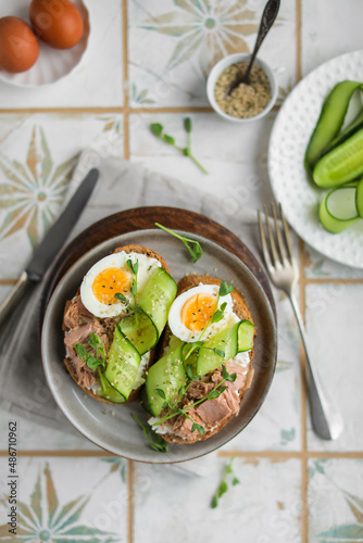 Sandwiches with wheat bread, cream cheese, canned tuna, fresh cucumber, boiled eggs and pea microgreens. A light, nutritious snack for a healthy lunch