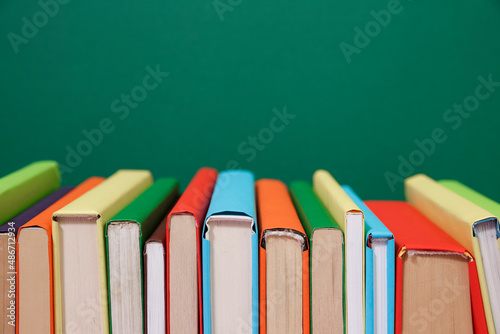 Composition with vintage old hardback books, diary, fanned pages on wooden deck table and colored background. Books stacking. Back to school. Copy Space. Education background.