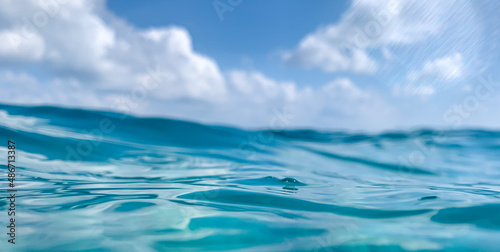 Blue sea or ocean water surface and underwater with sunny and cloudy sky. Amazing nature environment, ocean ecology nature closeup. Idyllic sea water horizon with dream sky view