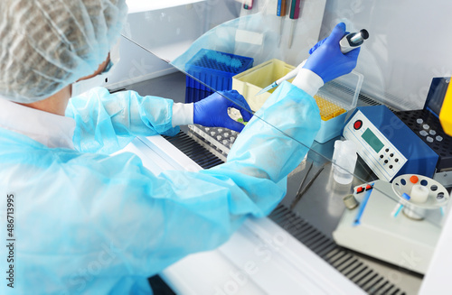 medical officer of the PCR laboratory conducts a study holding a dispenser in his hands.