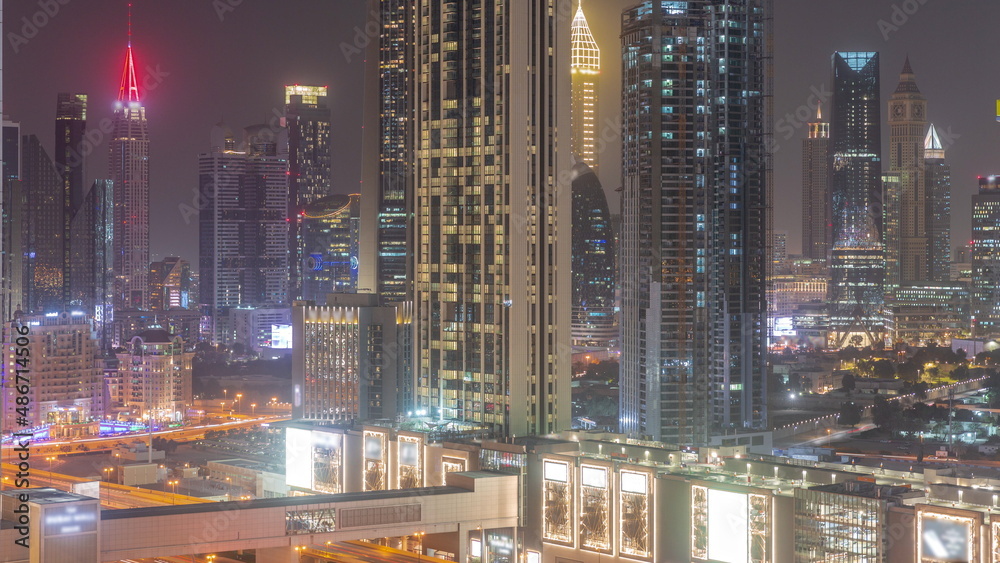 Fototapeta premium Row of the tall buildings around Sheikh Zayed Road and DIFC district aerial night timelapse in Dubai