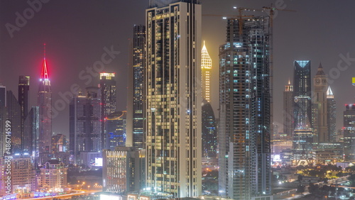 Row of the tall buildings around Sheikh Zayed Road and DIFC district aerial all night timelapse in Dubai