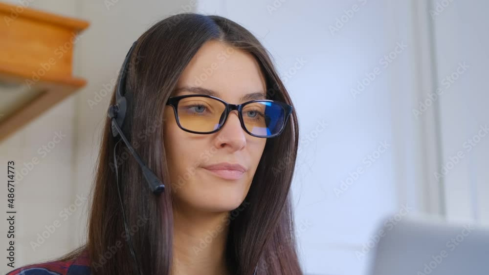 Online support operator in headset talking on web camera. Helpdesk specialist woman in nerdy glasses speaking with client on video call. 4k stock video of sales manager calling customer Online support operator in headset talking on web camera. Helpdesk specialist woman in nerdy glasses speaking with client on video call. 4k stock video of sales manager calling customer