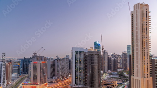 Skyscrapers at the Business Bay in Dubai aerial day to night timelapse, United Arab Emirates