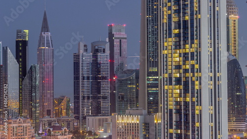 Row of the tall buildings around Sheikh Zayed Road and DIFC district aerial night to day timelapse in Dubai