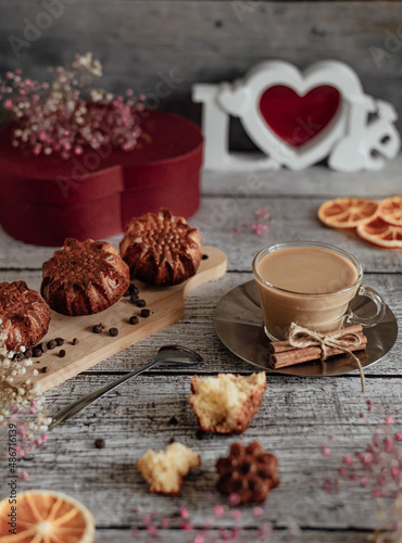 Fototapeta Naklejka Na Ścianę i Meble -  Homemade festive breakfast. Hot cappuccino coffee in a transparent mug and homemade and homemade muffin on a wooden table