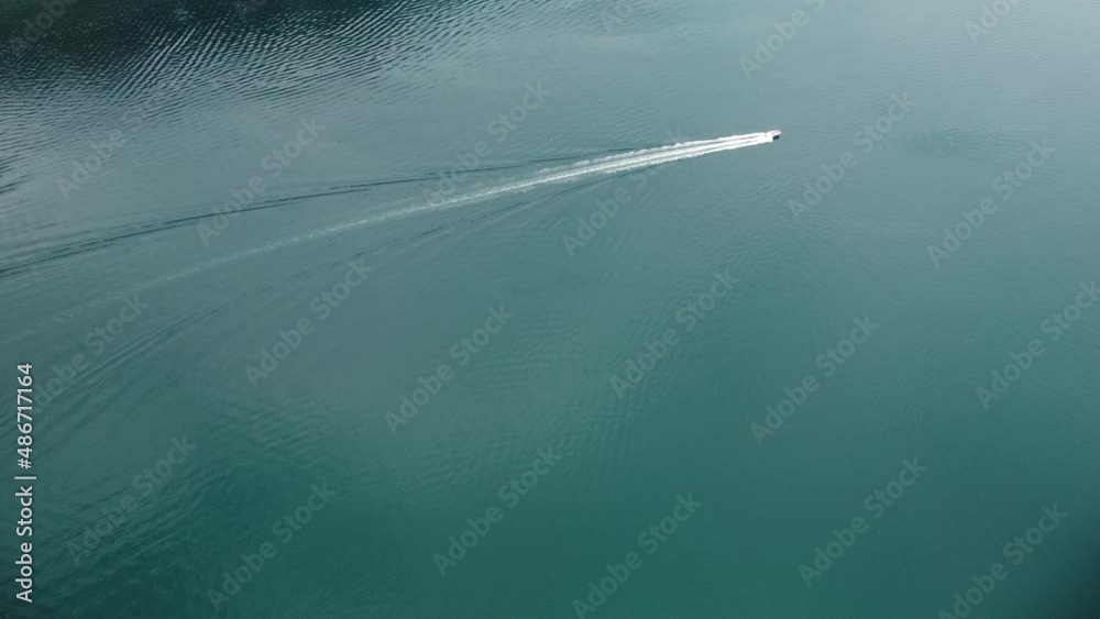 Aerial view of a white boat in the blue clear waters. Drone view of a yacht sailing to the blue sea. Large speed boat moving at high speed. travel, 4k Aerial view of a white boat in the blue clear waters. Drone view of a yacht sailing to the blue sea. Large speed boat moving at high speed. travel, 4k