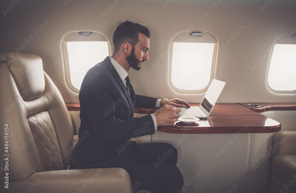 Businessman flying on his private jet. Successful business man and entrepreneur flying to his meeting. Famous salesman and speaker going to a sales event
