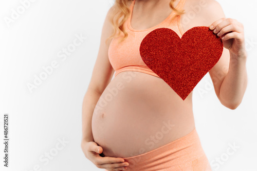 Wallpaper Mural Belly of a pregnant woman and a red heart on a white background.The concept of motherhood Torontodigital.ca