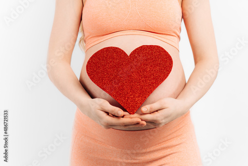 Wallpaper Mural Belly of a pregnant woman and a red heart on a white background.The concept of motherhood Torontodigital.ca