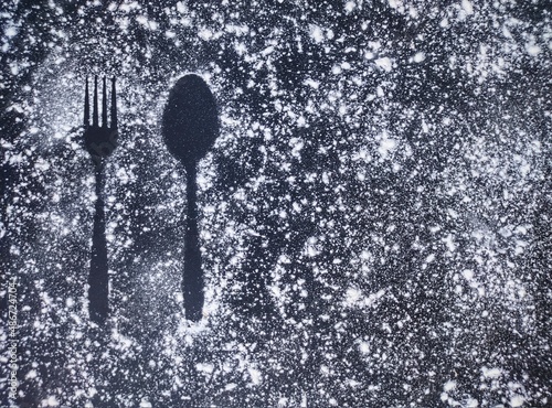 Fork and Spoon IMAGE ABOVE FLOUR, BLACK BACKGROUND. 12 FEBRUARY 2022 INDONESIA photo