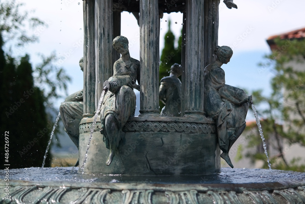 stone fountain in the shape of a woman pouring water from a jar.