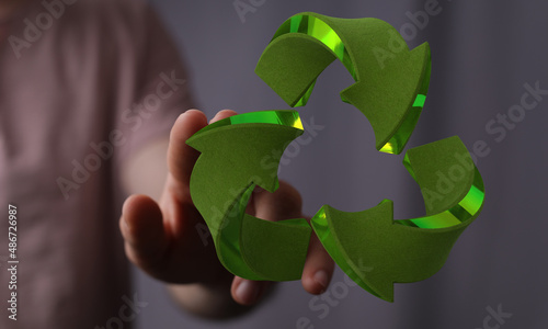 hand holding green recycle symbol photo