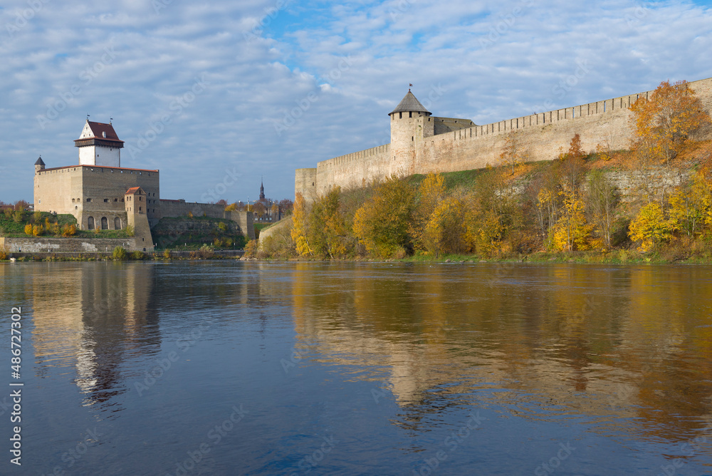 Herman's castle and Ivangorod fortress on Narva river in golden autumn. Border of Russia and Estonia