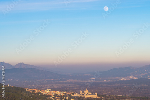 View of El Escorial monastery with a full moon and visible air pollution