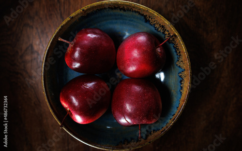 4 red apples in clay bowl