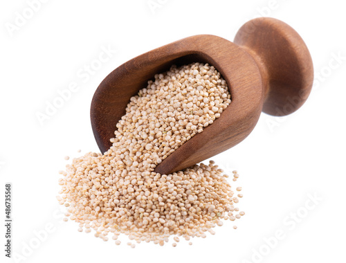 White quinoa seeds in wooden scoop, isolated on white background. Pile of raw kinwa.