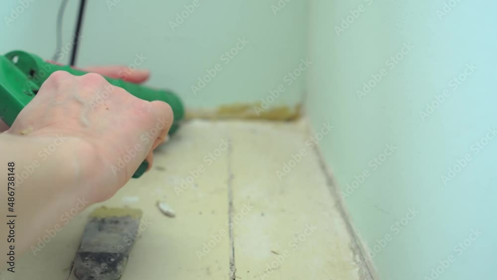 Preparing the wall for fixing baseboard. Closeup of the hand of a
