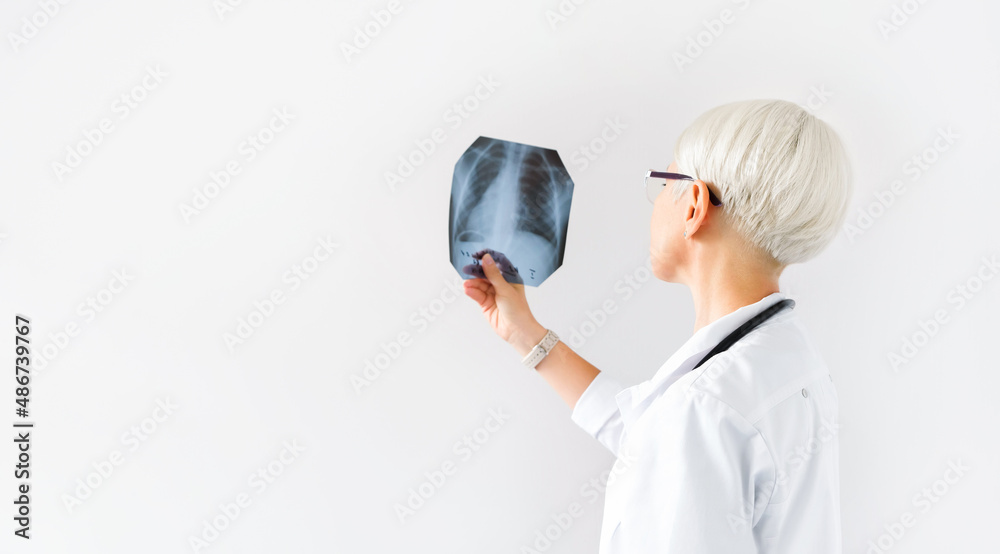 Doctor checking analyzing x-ray film of chest radiograph lungsin hospital. Control and monitoring diseases respiratory organs. Pulmonology concept. Copy empty space for text. Doctor checking analyzing x-ray film of chest radiograph lungsin hospital. Control and monitoring diseases respiratory organs. Pulmonology concept. Copy empty space for text.