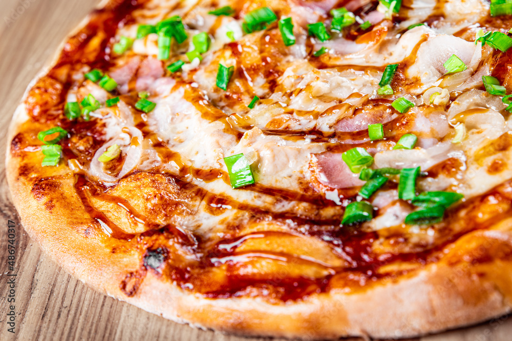Pizza with chicken, cheese and barbeque sauce. Italian pizza on wooden table background Pizza with chicken, cheese and barbeque sauce. Italian pizza on wooden table background