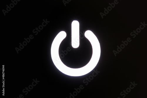 Glowing power button on black background