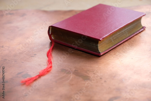 Red paper pocket book with a red bookmark on a copper background. Selective focus. 