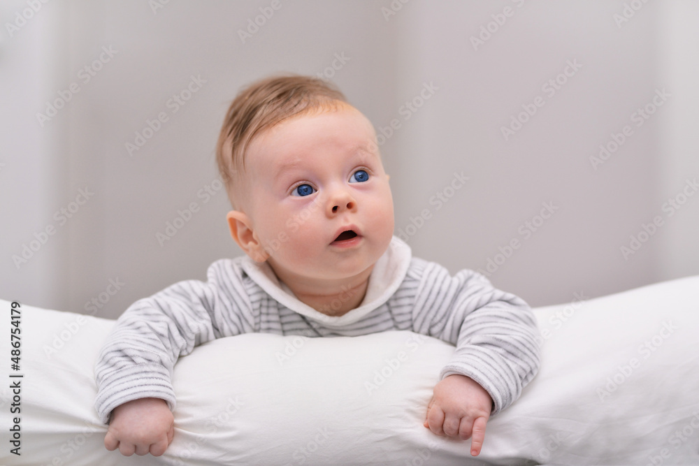 Beautiful 4 months old baby crawling on bed. European cute baby smile and crawling.