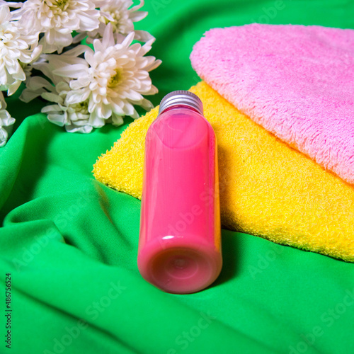 Spa set for body care, a bottle of gel for spa procedures lies on bath towels on a green background, copy space, flat lay, template