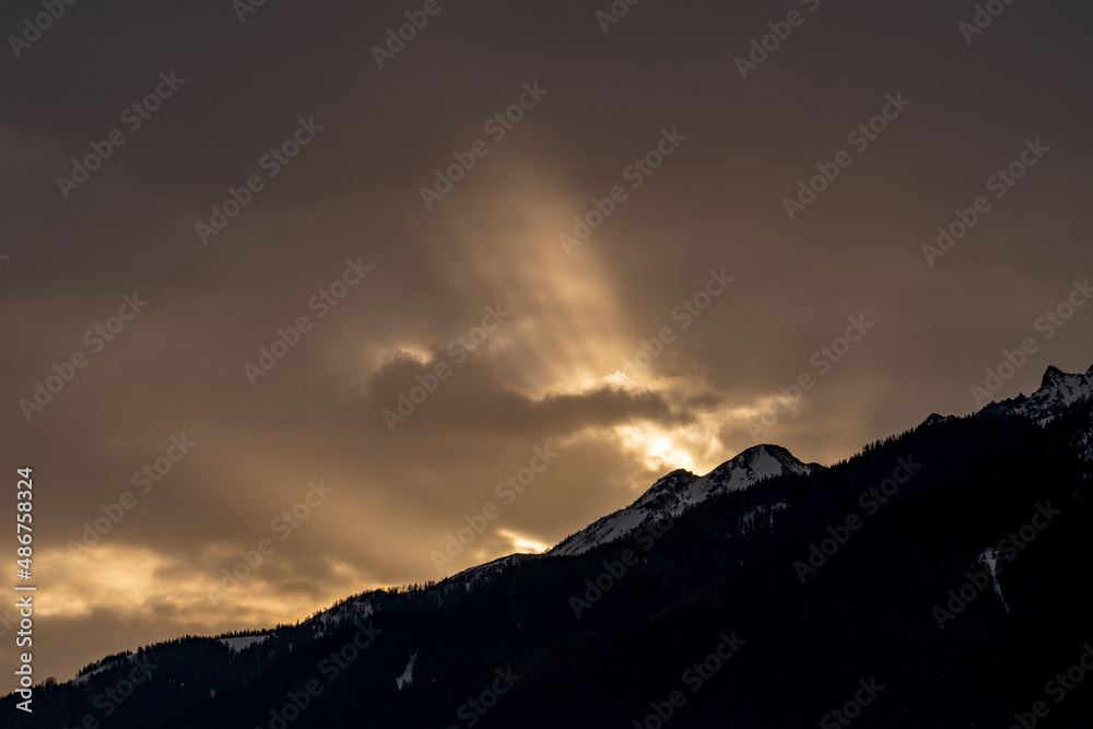 Obraz premium beautiful sunrise with a golden sky and mountain silhouette