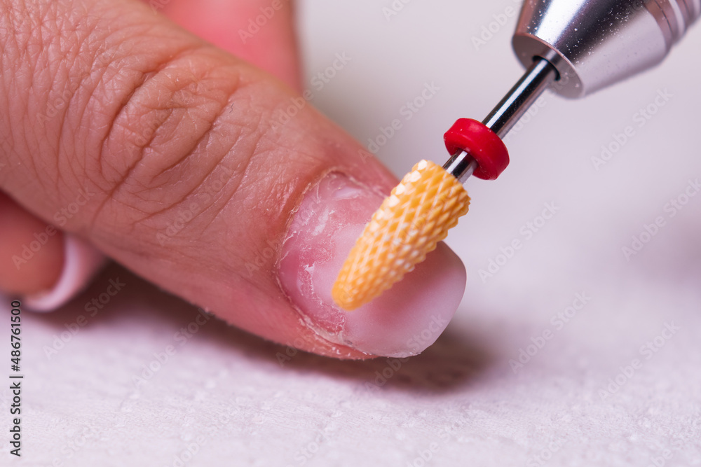 removing the gel polish coating from the nails with a ceramic cutter