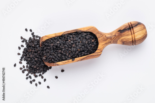 Bio natural black sesame seeds on wooden spoon.