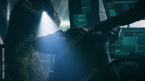 Photos Male hacker raising hands behind head while police in uniform with guns arrestin