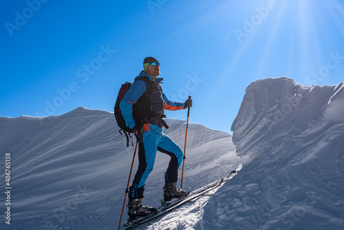 ski tourer enjoys the sun rays on the top of the mountains.