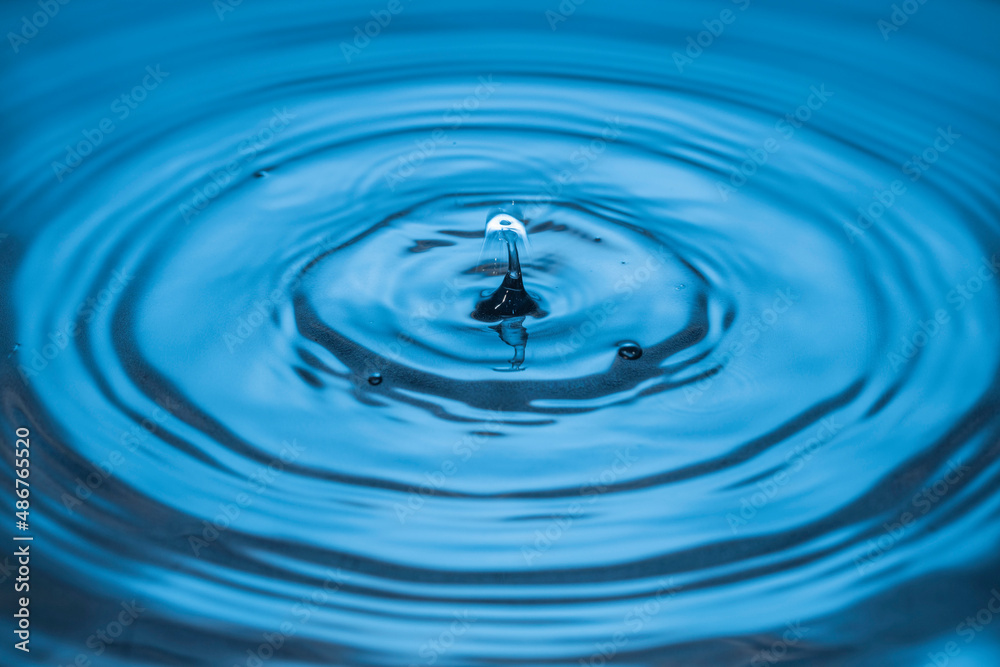 Beautiful view of drops making circles on blue water surface isolated on background. Beautiful view of drops making circles on blue water surface isolated on background.
