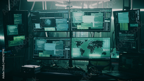 Pan around view of modern computer monitor with world map and various data located on desk in dark room of hacker base